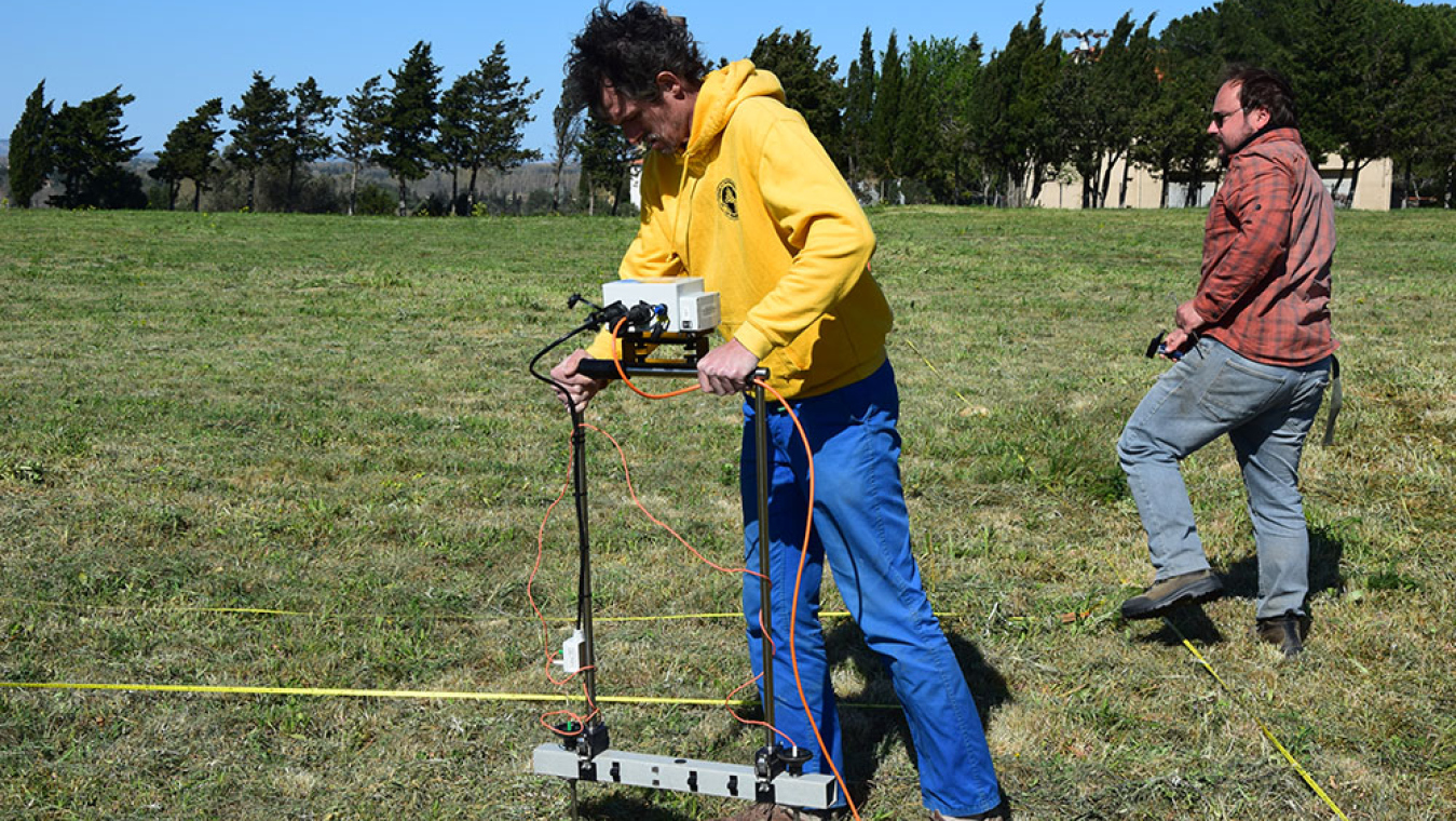 Chercheurs passant le résistivimètre sur les terrains au nord du forum