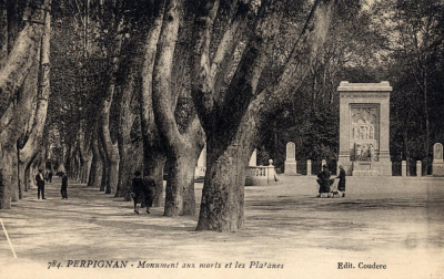photo:à gauche allées de platanes ; a droite:le monument rectabgulaire entouré de ses 4 stèle avec mosaîque