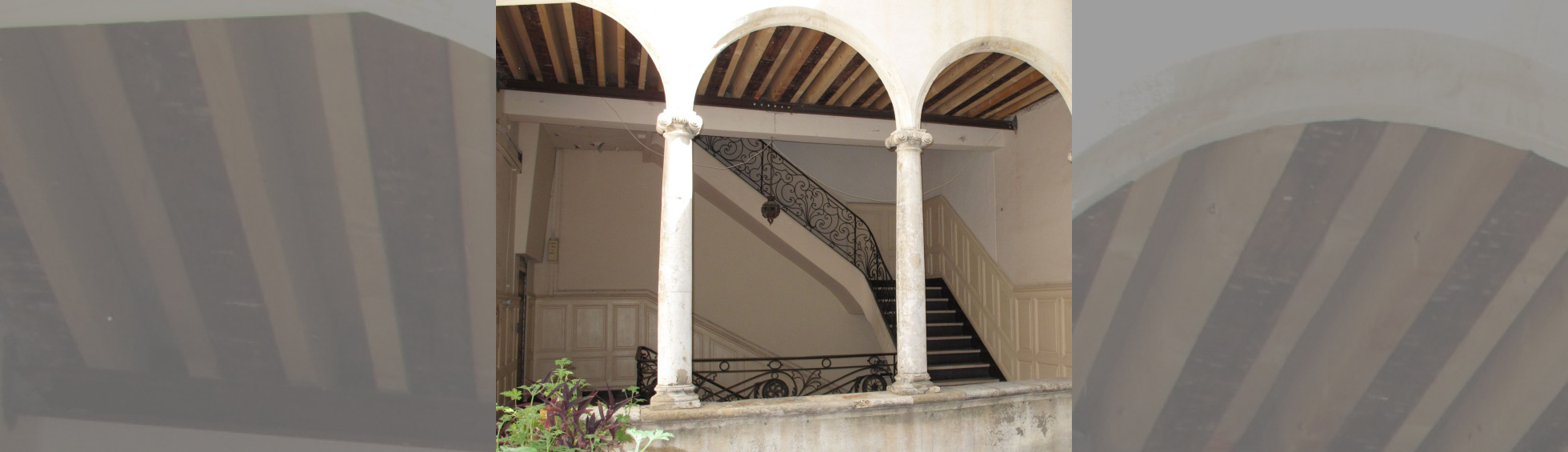 Colonnade avec arc de plein cintre, escalier et rampe en fer forgé du style 18 ième 