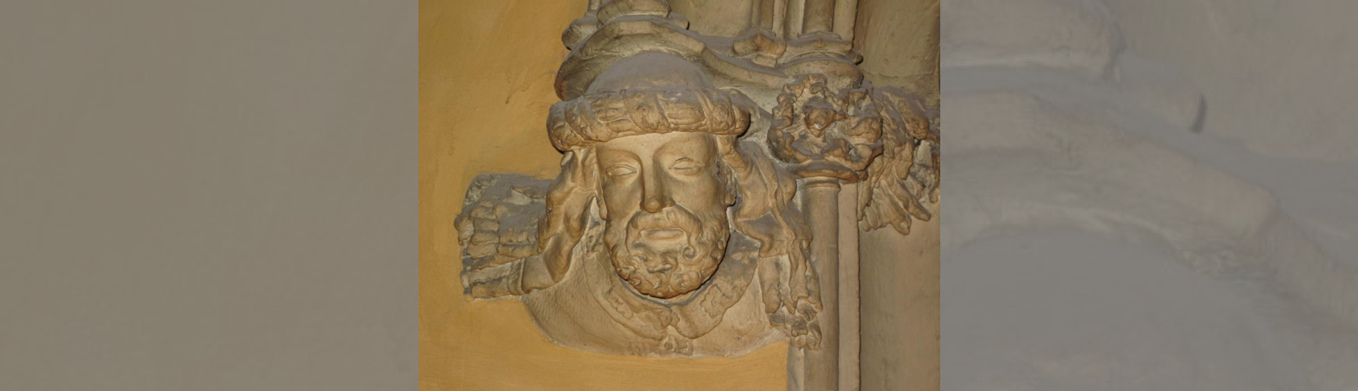 Tête décorative de Bernat Xanxo à la base d'un encadrement de porte côté gauche