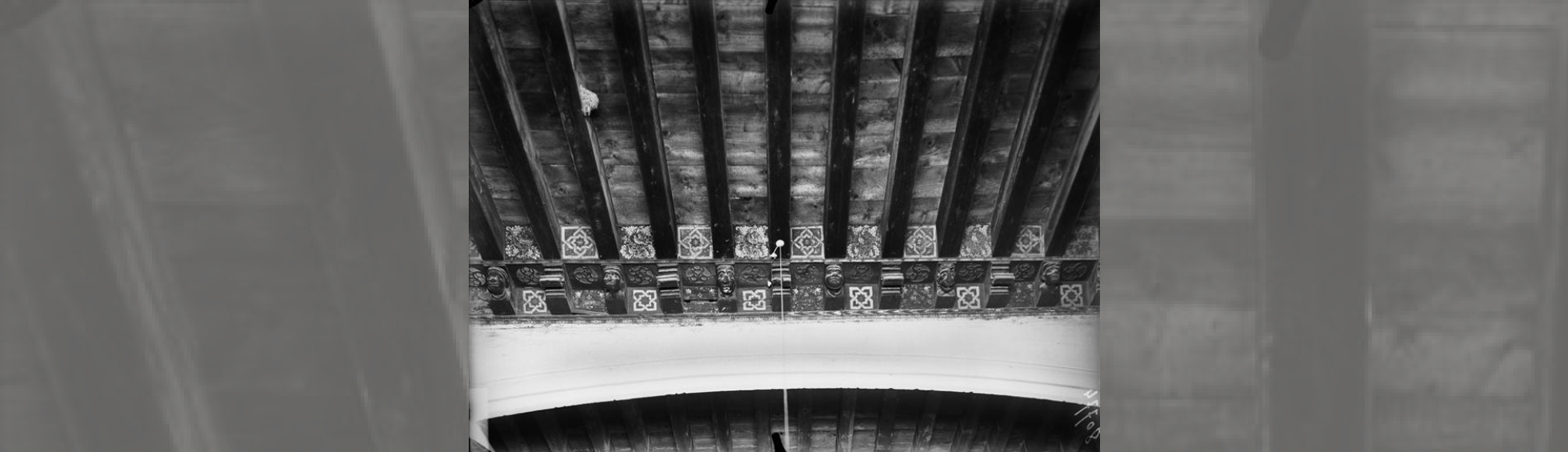 Plafond de la tribune peint avec des motifs géométriques  et  corbeaux de poutre à têtes sculptées